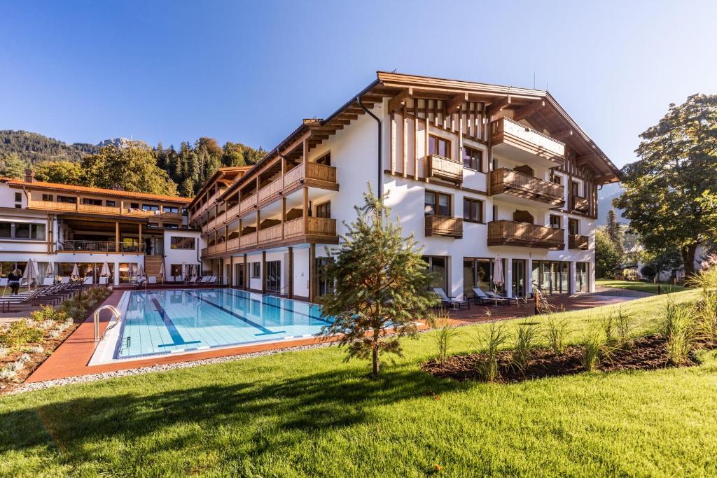 贝里斯泽尔Das Bayrischzell Familotel Oberbayern的享有酒店外景,设有游泳池