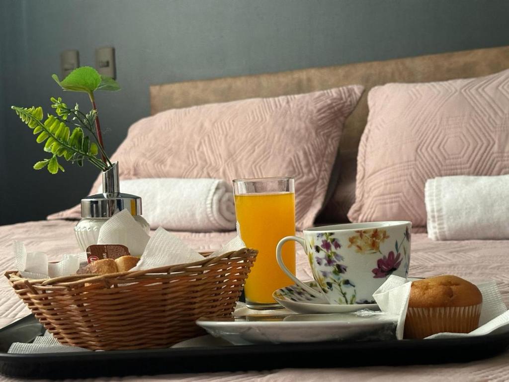 康塞普西翁Hotel Vitali的床上的托盘,包括早餐食品和饮料