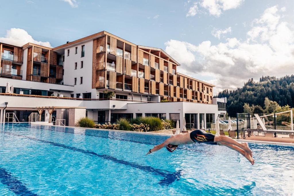 布里克森谷地霍普夫加尔滕Das Hohe Salve Sportresort, 4 Sterne Superior的在一个酒店的游泳池游泳的人