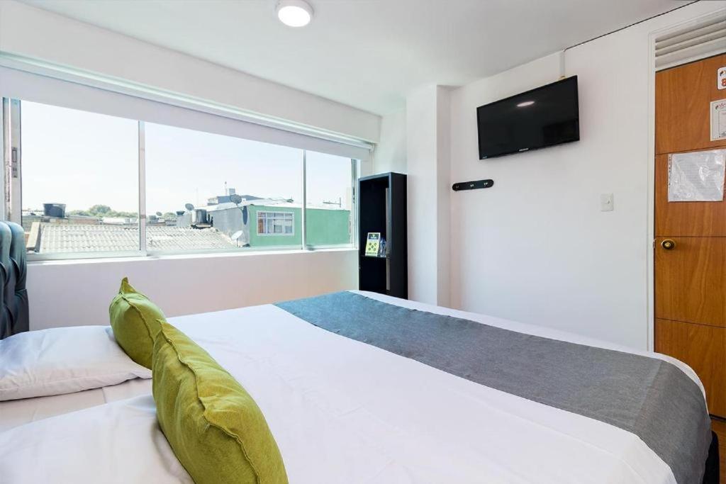 波哥大Bogotá Elite的一间卧室设有一张床和一个大窗户