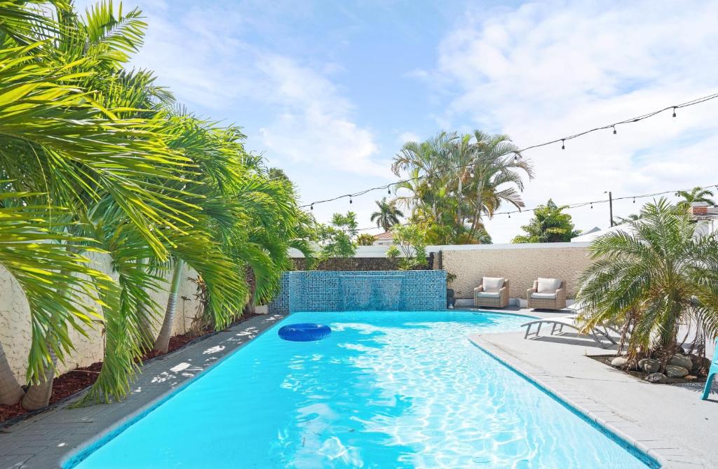 多拉多4 bedroom family reserve with pool home的棕榈树后院的游泳池