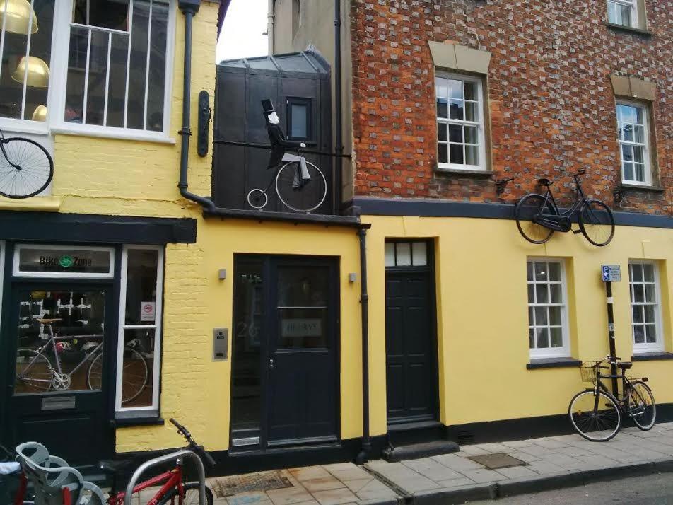 牛津亨利旅馆的一座黄色的建筑,旁边是自行车