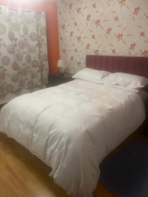 伦敦Chislet的卧室配有白色床和粉红色床头板