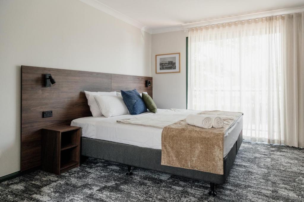 黄金海岸Wallaby Hotel的一间卧室设有一张大床和一个窗户。