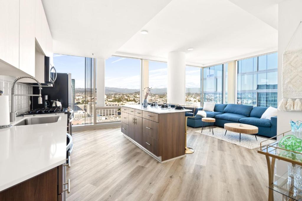 洛杉矶Upscale city view High Rise W/ private parking的厨房以及带蓝色沙发的客厅。