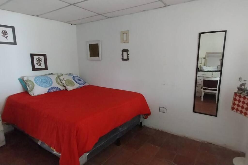 阿马蒂特兰Jardín Paraíso的一间卧室配有红色的床和镜子