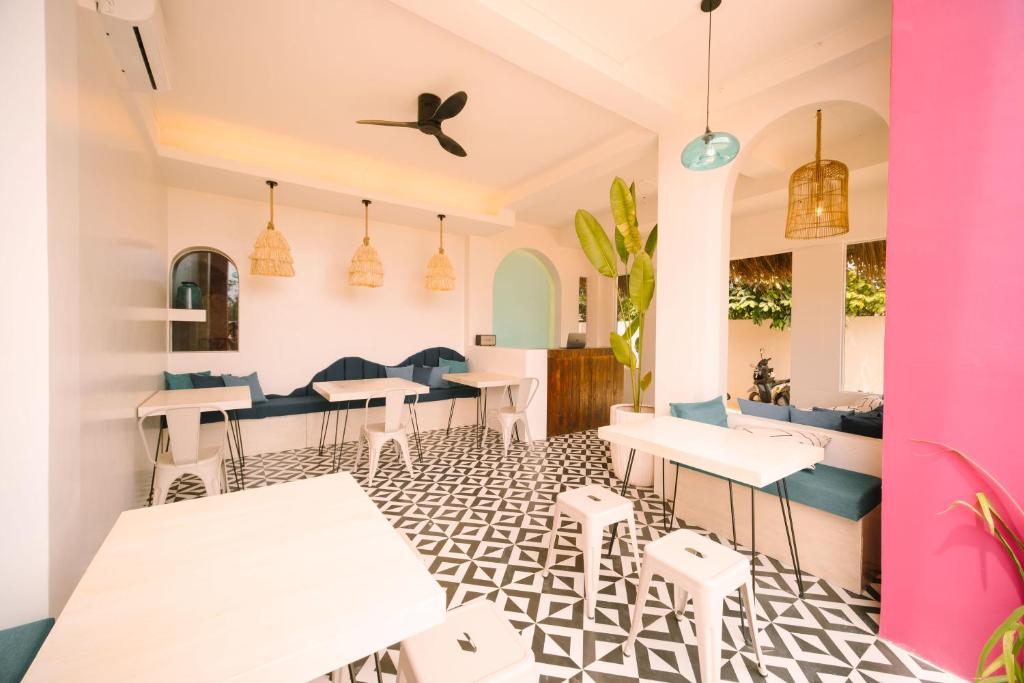 卢纳将军城BIG WAVES BOUTIQUE HOTEL SIARGAO的餐厅设有白色的桌子和蓝色的椅子