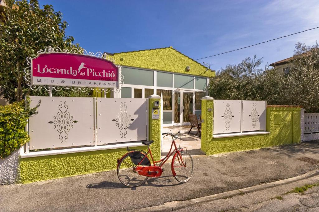 洛雷托乐堪达德尔皮齐尔旅馆的停在大楼前的一辆红色自行车