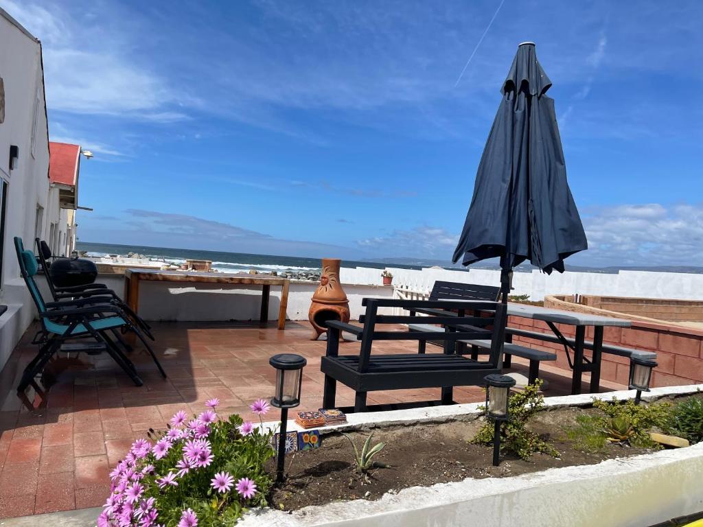 恩塞纳达港Baja Azul的庭院配有遮阳伞和桌椅。
