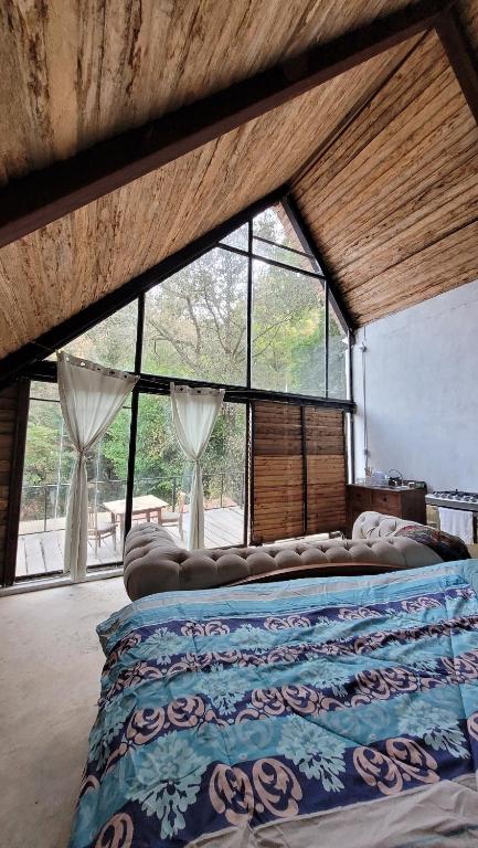 San Lucas SacatepéquezCabaña privada的配有大窗户的客房内的一张大床