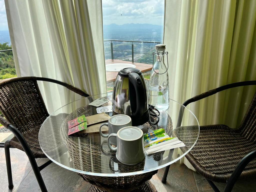 佩雷拉Glamping ríos voladores pereira的茶壶和茶杯的玻璃桌