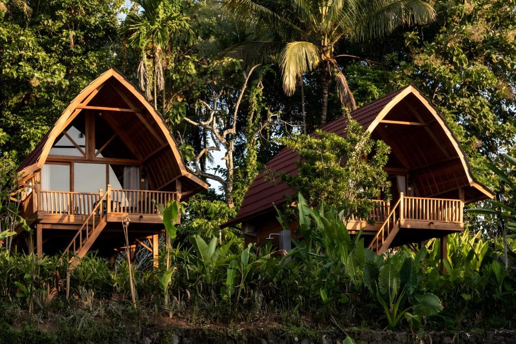 塞莱马德加Kusfarm Bali的树林中的两栋树屋
