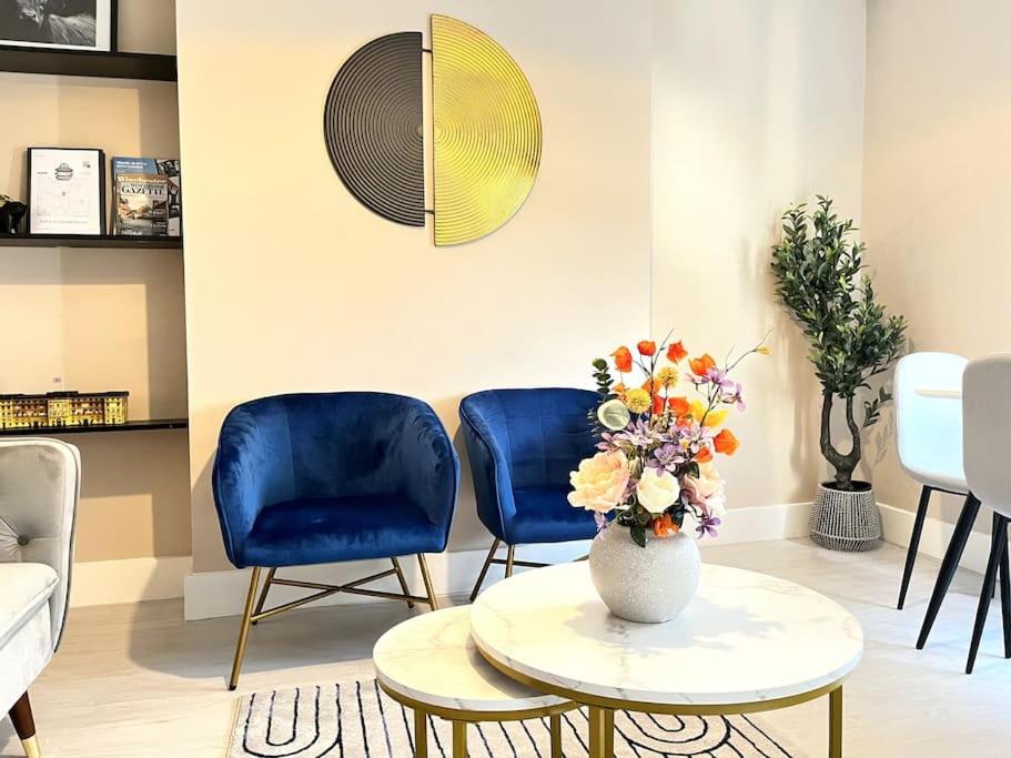 温彻斯特Central Winchester Serviced Apartments的客厅配有2把蓝色椅子和花瓶