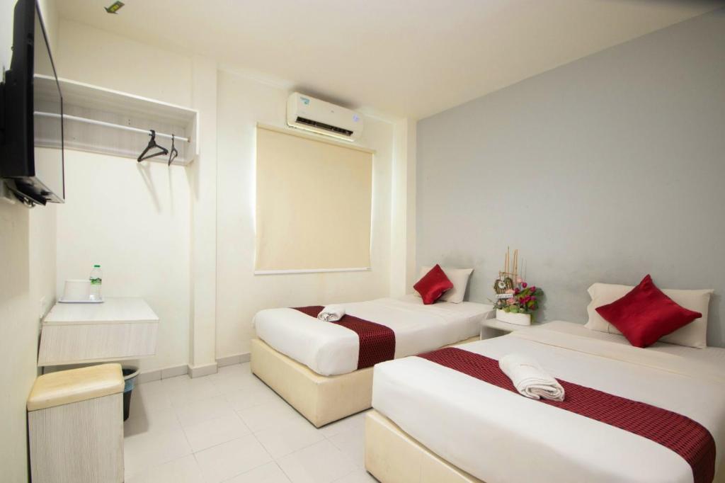 马六甲Sun Inns Hotel Kota Laksamana Melaka的酒店客房设有两张床和盥洗盆