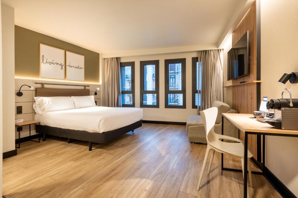 圣塞瓦斯蒂安Leonardo Boutique Hotel San Sebastián的配有一张床和一张书桌的酒店客房