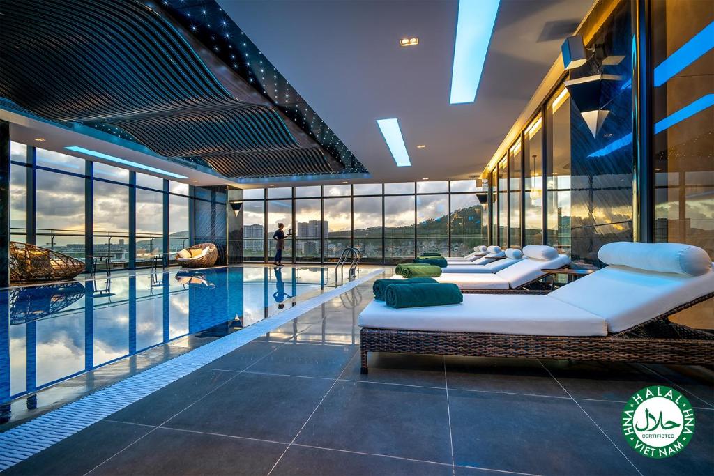下龙湾DeLaSea Ha Long Hotel的带游泳池的客房内的两张床
