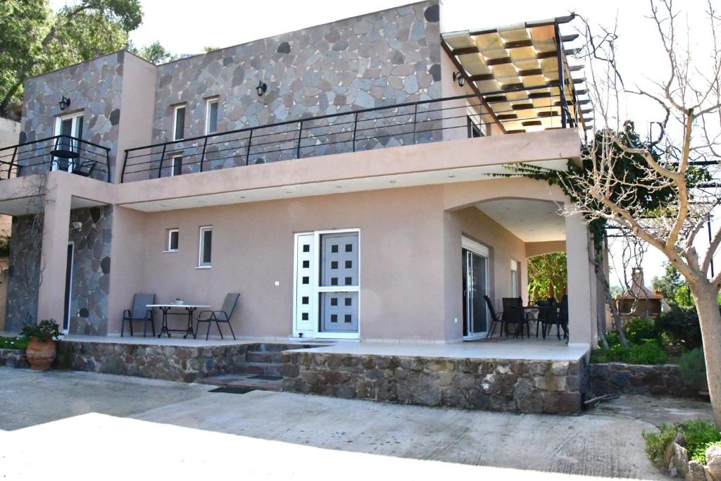 阿吉亚玛丽娜Sanctuary Villa in Vagia, Aegina的带阳台和庭院的度假屋