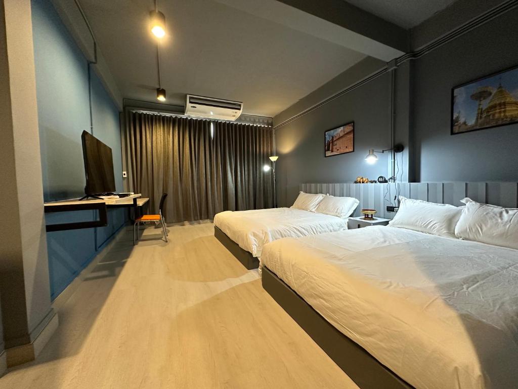 曼谷Bangkok vibe, City House, 7 mins to BTS, City center, Private room in Sathon, Private bathroom, Bangkok, Thailand的酒店客房设有两张床和电视。