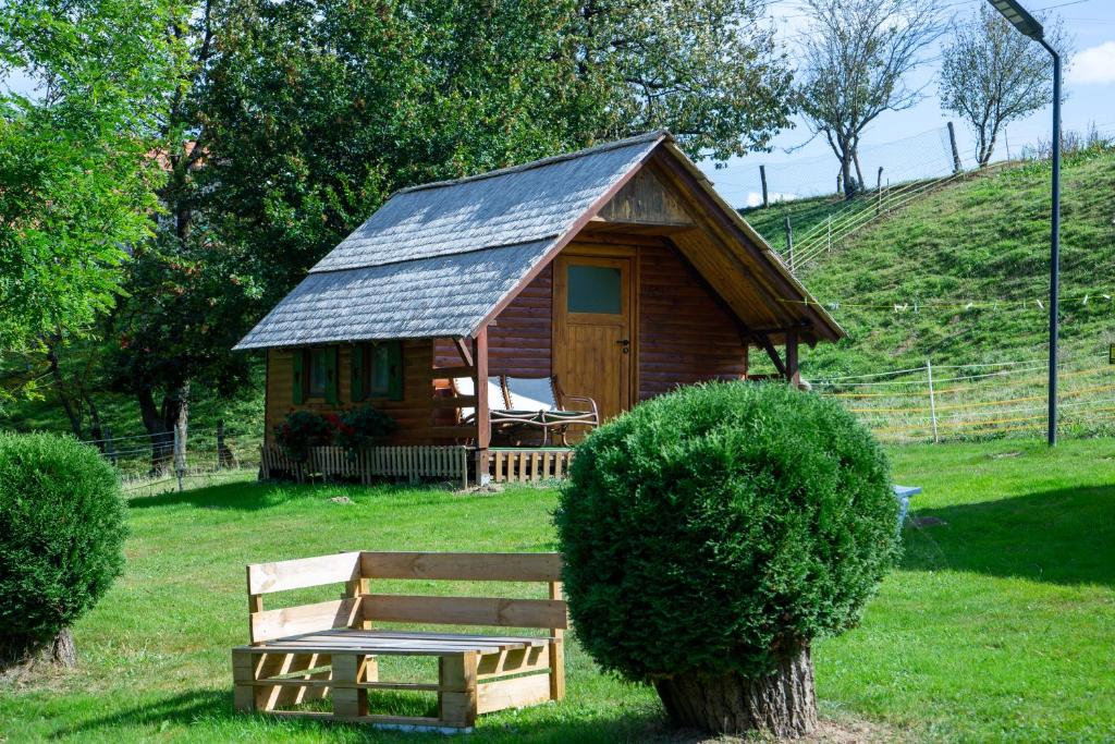 柳托梅尔Camping Silva的小屋,设有长凳,位于草地上