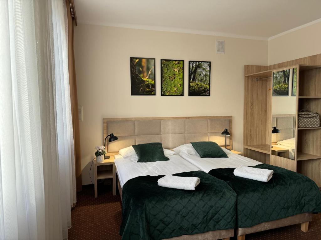 卡托维兹扎伦泽酒店的一间卧室配有一张床,上面有两条毛巾
