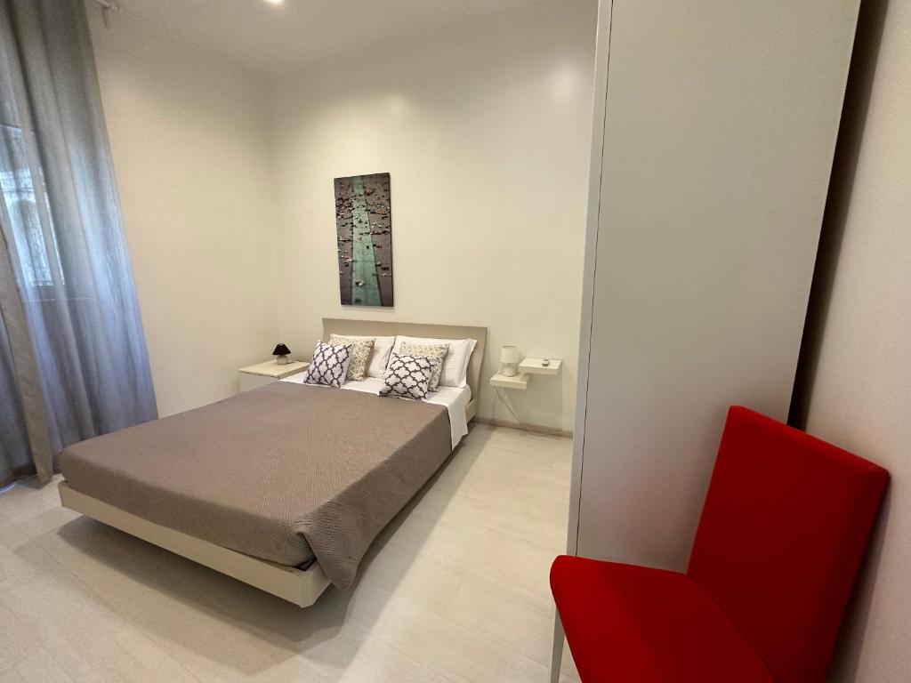 罗马罗马度假屋 的一间卧室配有一张床和一张红色椅子