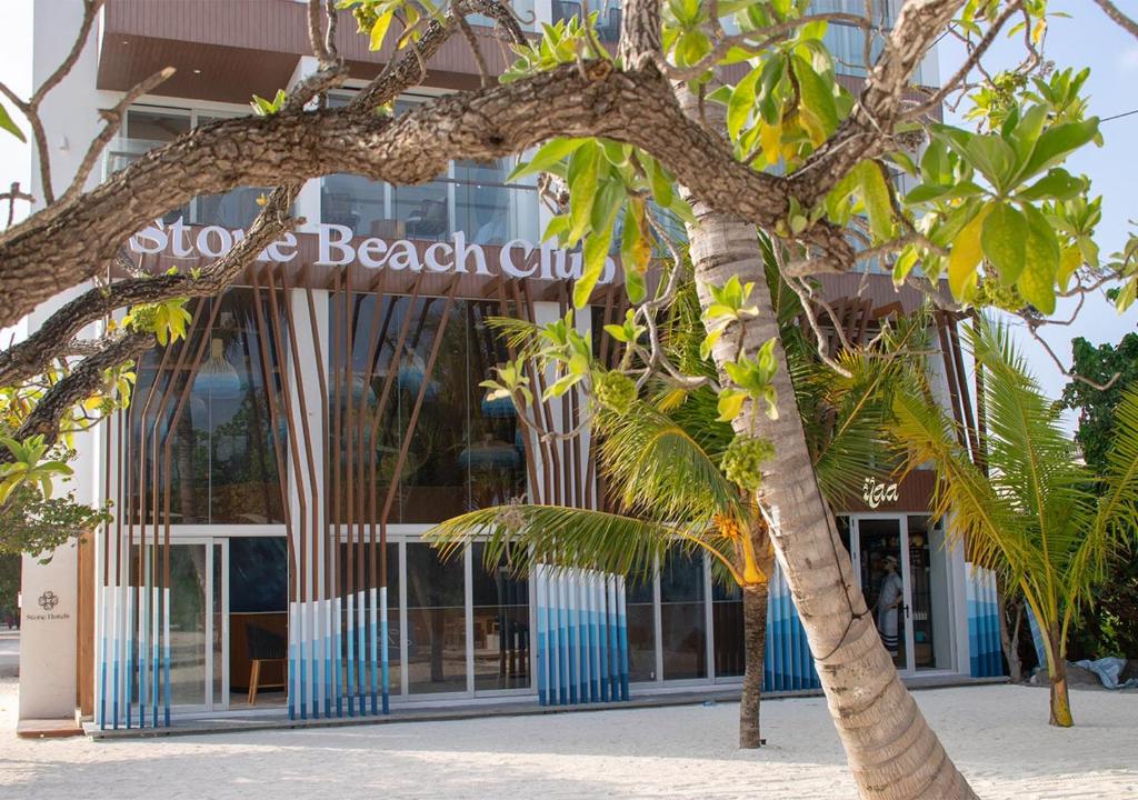 迪弗西Stone Beach Club的带有读取停机和海滩俱乐部标志的建筑