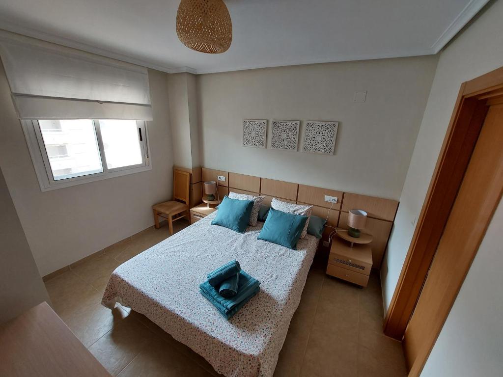 奥罗佩萨德尔马Apartamento Neptuno Sunrise Magic World的一间卧室配有一张带蓝色枕头的大床