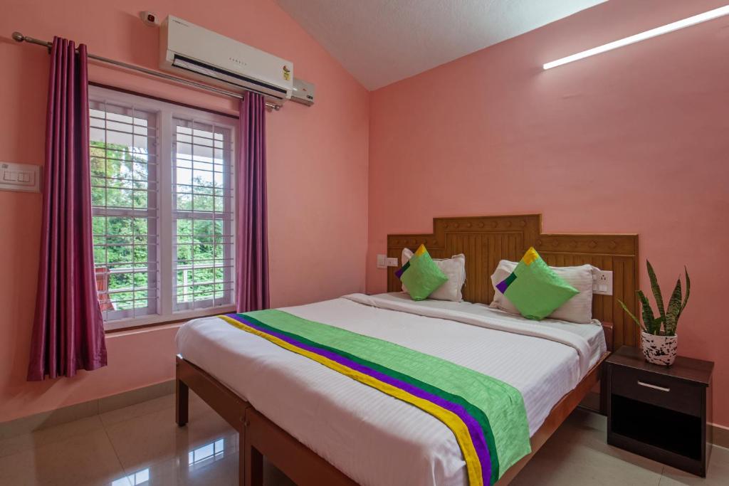 马迪凯里Treebo Trend Yajna Comforts的卧室配有一张带粉红色墙壁的大床