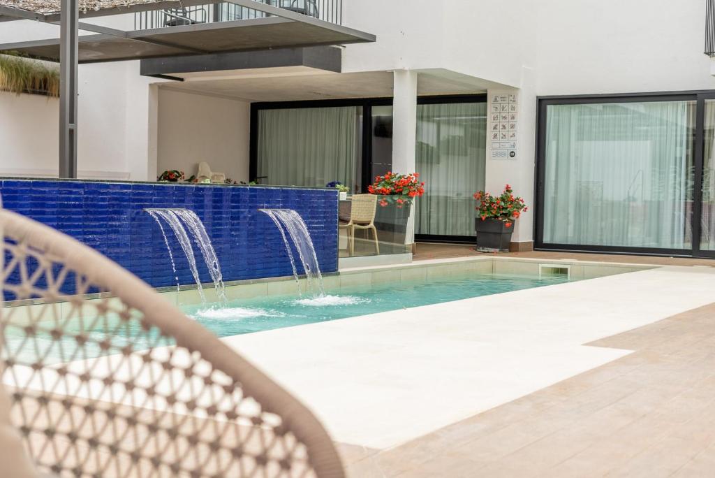 卡里拉Neptuno Apartments的一座带房子的建筑中的游泳池
