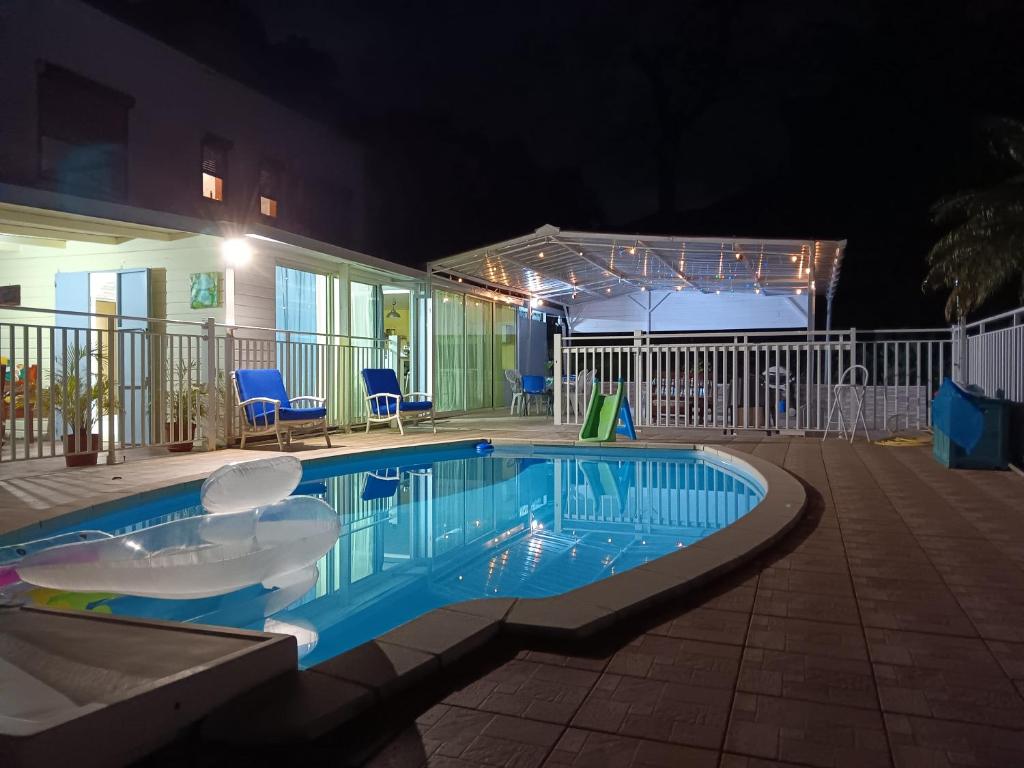 戈亚夫Villa de 3 chambres avec piscine privee jardin clos et wifi a Goyave a 6 km de la plage的夜间在院子里的游泳池