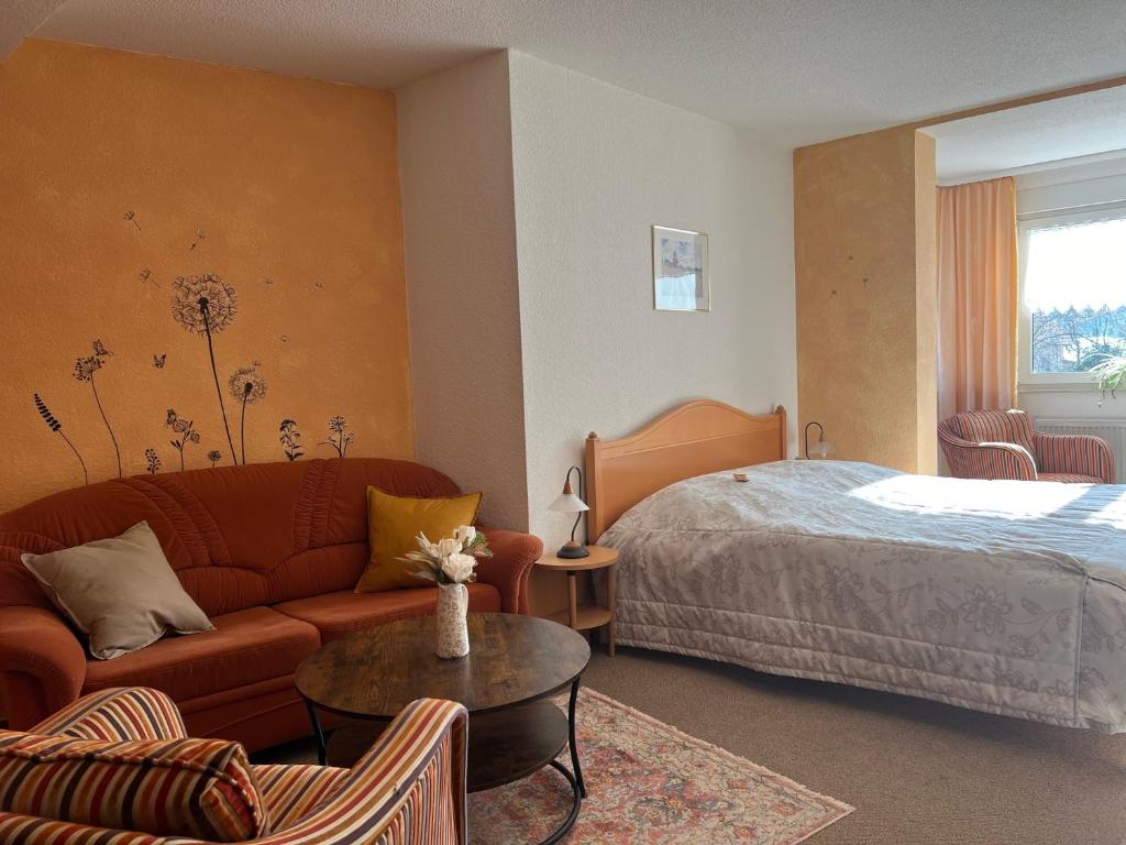 奎德林堡Landhaus Pusteblume的酒店客房配有床、沙发和桌子。