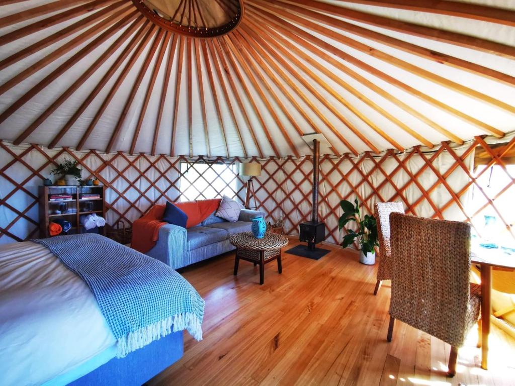 TarakohePetal Creek Farm的蒙古包内带一张床和一张沙发的房间