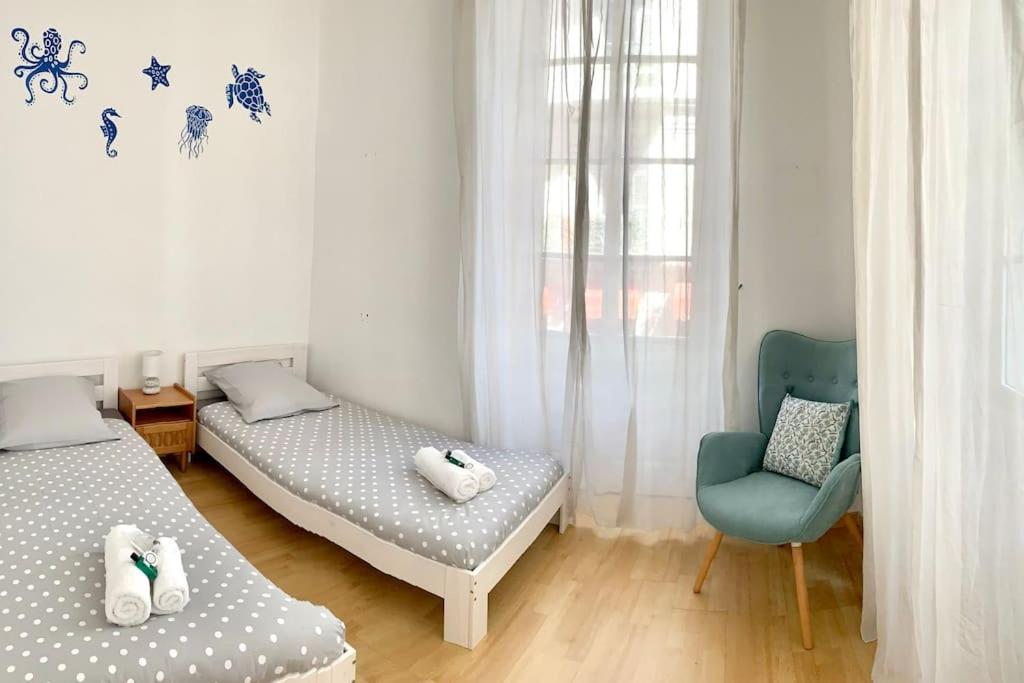 尼斯Saint Philippe - T3 Terrasse près de la plage的一间卧室配有两张床和一张蓝色椅子