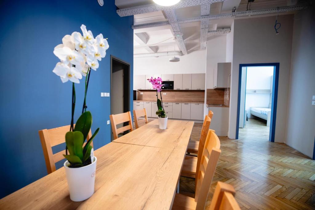 马里博尔CafDorm的用餐室配有白色花卉木桌