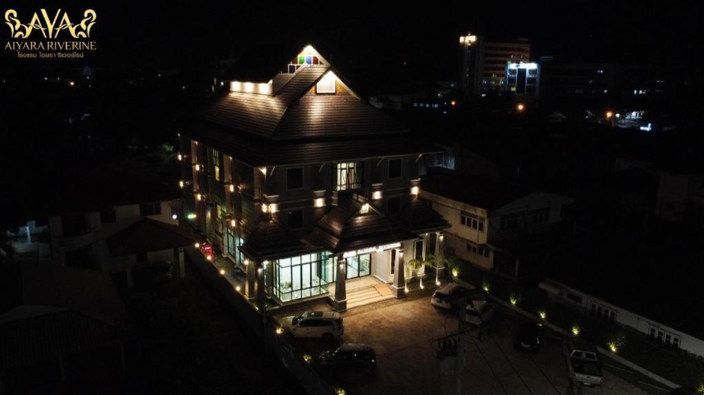 Ban Nong Pukโรงแรม ไอยรา ริเวอร์ไรน์ นครพนม (AIYARA RIVERINE)的夜晚,房子的一侧有灯
