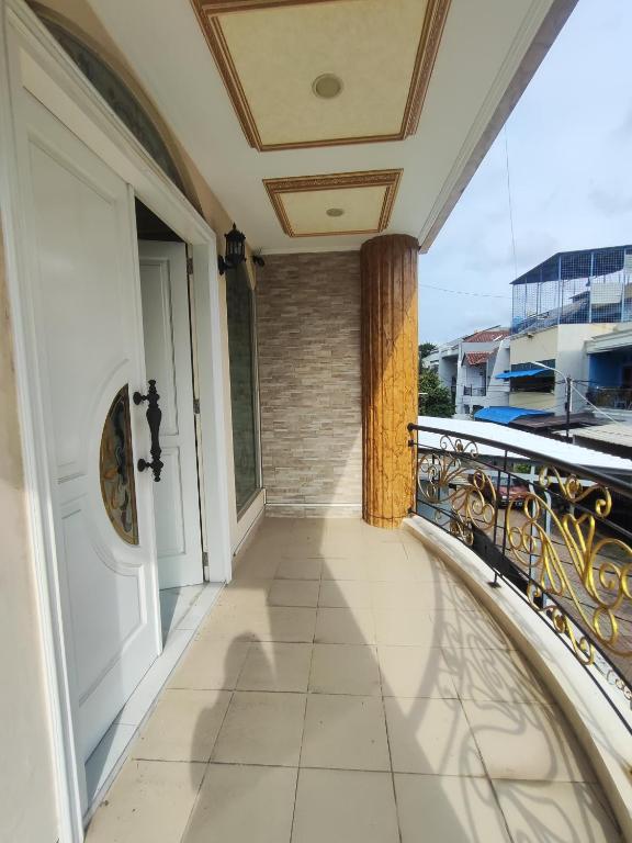 雅加达Rumah liburan 2 bedroom, 1 sofabed, 1 kitchen的阳台设有白色门和栏杆