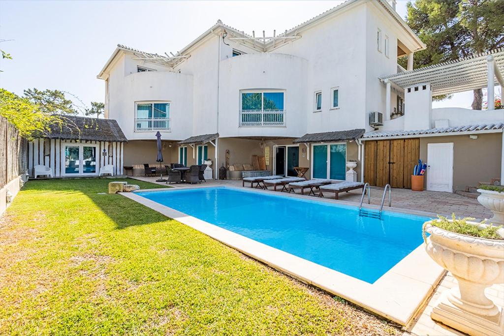 孔波尔塔Kochab Comporta的一座大型白色房子,在庭院里设有一个游泳池
