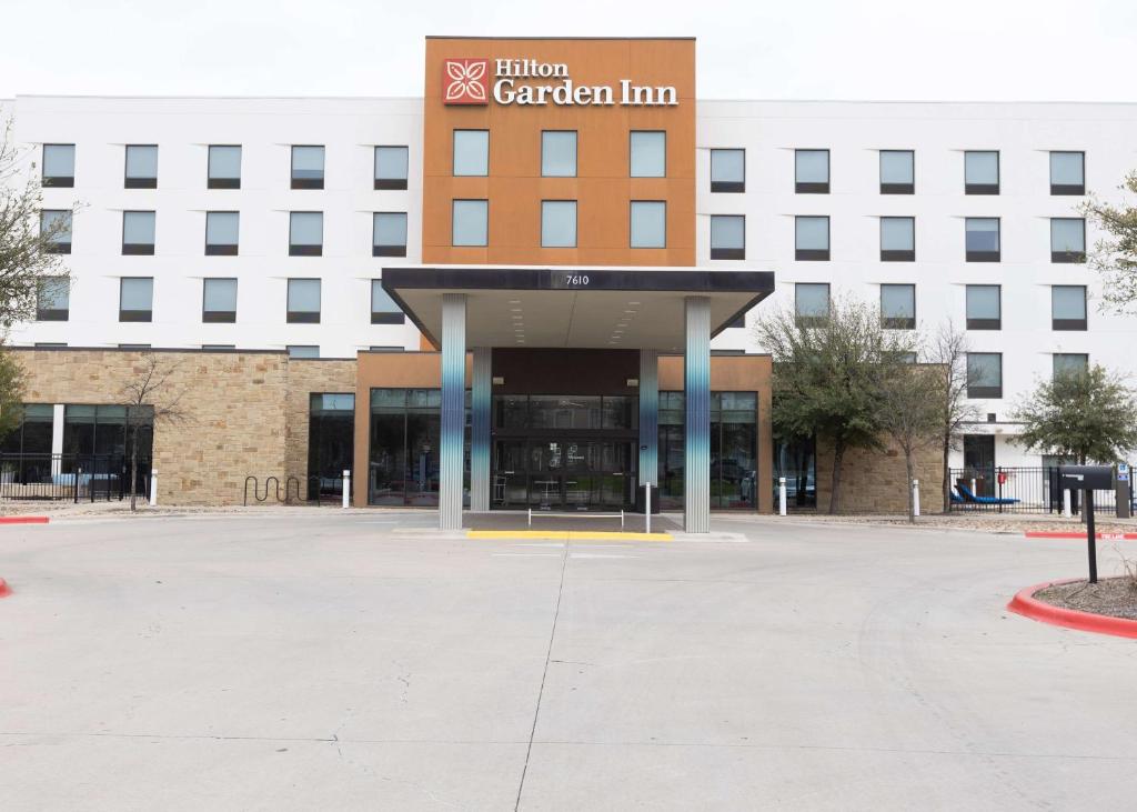 奥斯汀Hilton Garden Inn Austin Airport的大楼前的一个空停车位