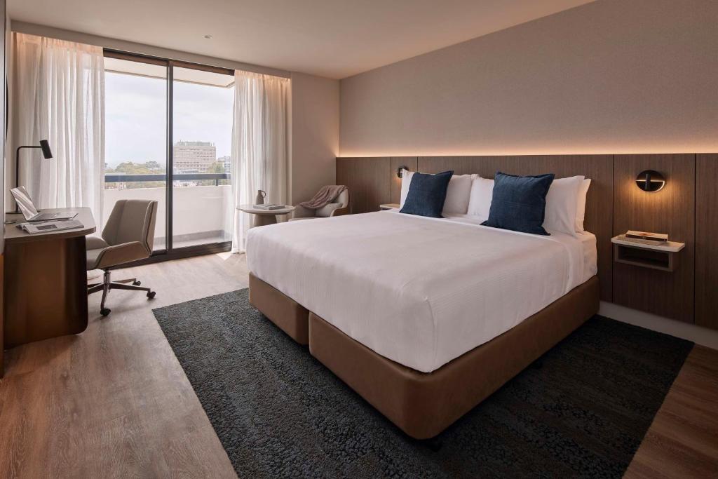 悉尼The Miller Hotel North Sydney的酒店客房设有一张大床和一张书桌。