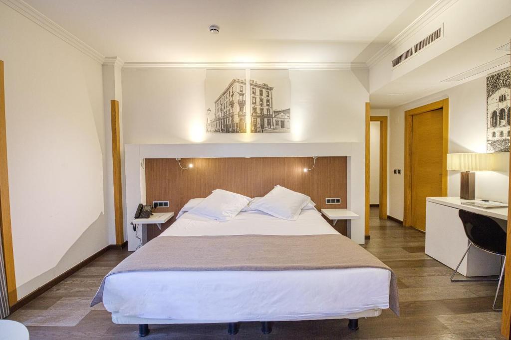 奥维多Gran Hotel España的酒店客房设有一张大床和一个厨房。