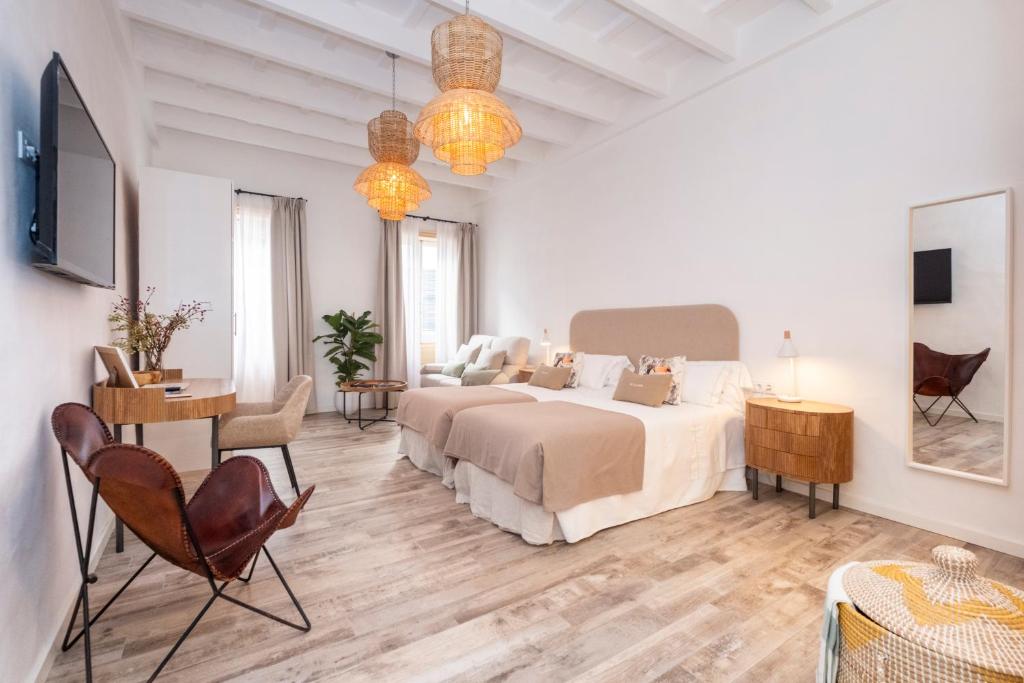 阿莱奥尔Encant de Alaior Boutique Hotel的白色卧室配有床、书桌和椅子