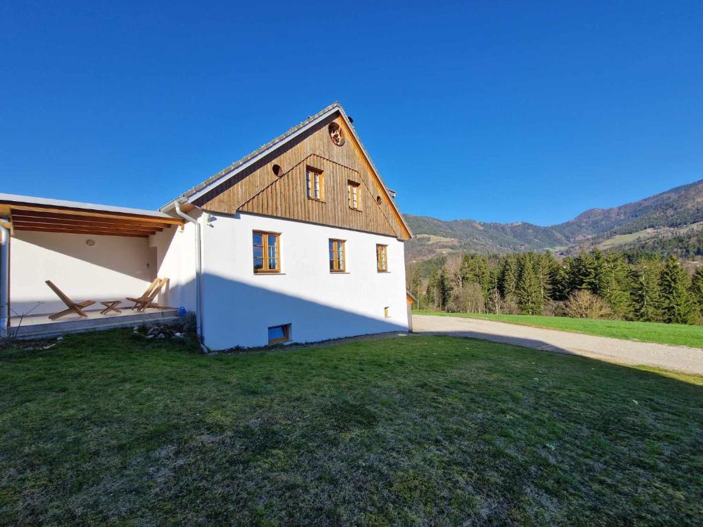 Gornji GradParadise Oasis holiday house的绿色田野上白色的房屋,屋顶为棕色
