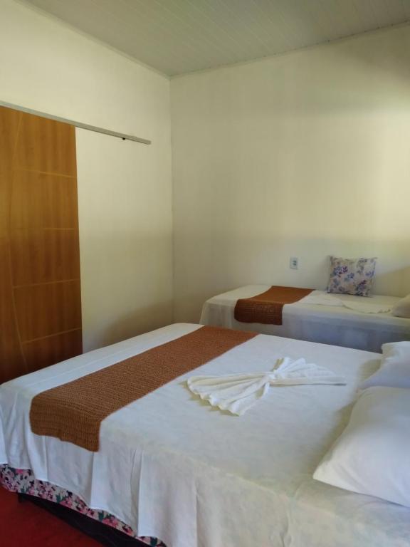 库穆鲁沙蒂巴Chalé Ilha Verde-Cumuruxatiba的两张位于酒店客房的床,配有毛巾