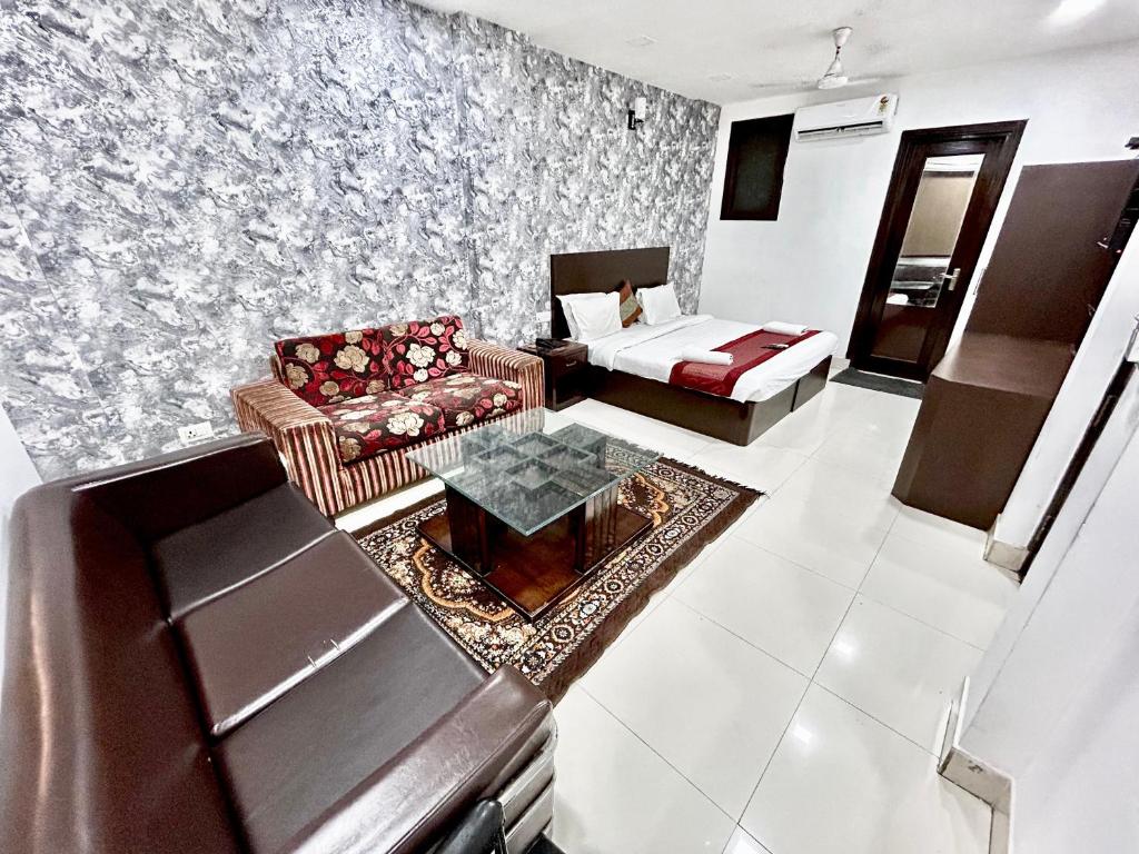 新德里Hotel Siam International的客厅配有沙发和桌子
