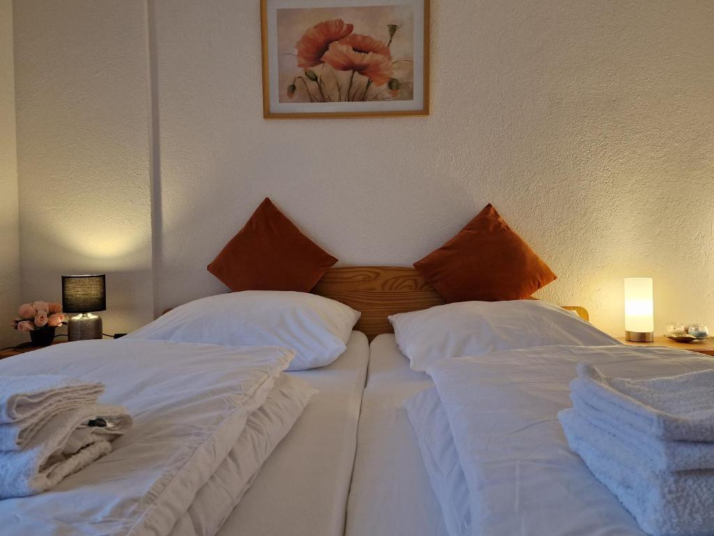 特里贝格Holiday Apartment near Triberg Waterfall的配有白色床单的酒店客房内的两张床