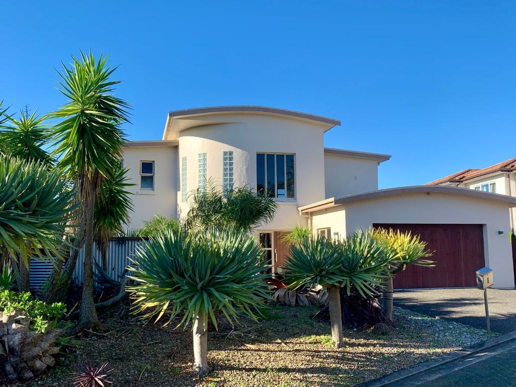 奥克兰Amazing Seaview House的一座棕榈树掩映的白色房子