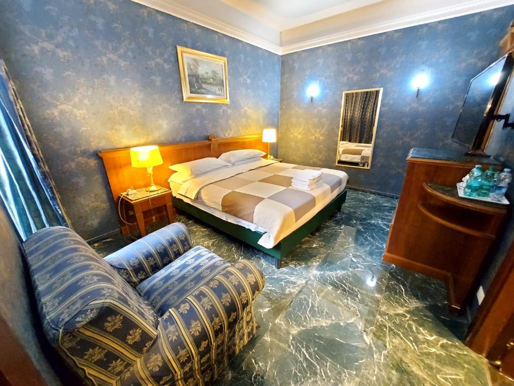 罗马Hotel Positano 2的一间卧室配有一张床、一张沙发和一把椅子