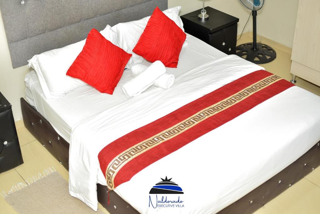 内尔斯普雷特Naldorado Executive Villa的一张带红色和白色枕头的床