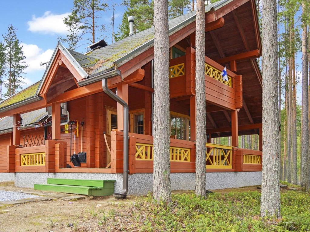 YlämyllyHoliday Home Villa käpytikka by Interhome的树林里树木繁茂的大型木屋