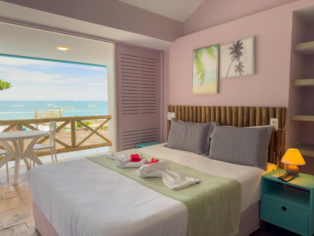 马拉戈日Pousada Meraki Beach的一间卧室设有一张床,享有海景